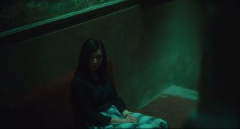 Movie still from “Days of Being Wild” (1990), directed by Kar-Wai Wong – A woman sitting on a bench in a dark room; Medium shot, High angle