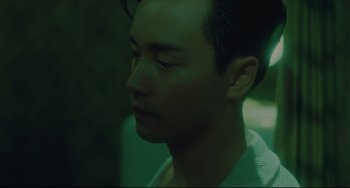 Movie still from “Days of Being Wild” (1990), directed by Kar-Wai Wong – A man's face in the dark; Close Up shot, Over the shoulder angle