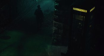 Movie still from “Days of Being Wild” (1990), directed by Kar-Wai Wong – A man is standing in the dark near a building; Wide shot, Low angle