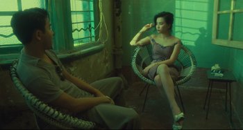 Movie still from “Days of Being Wild” (1990), directed by Kar-Wai Wong – Two women sitting in a chair in a room; Wide shot, High angle