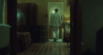 Movie still from “Days of Being Wild” (1990), directed by Kar-Wai Wong – A man walking through a doorway in a room; Wide shot, Over the shoulder angle
