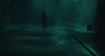 Movie still from “Days of Being Wild” (1990), directed by Kar-Wai Wong – A person standing in the middle of a dark area; Extreme Wide shot, Over the shoulder angle