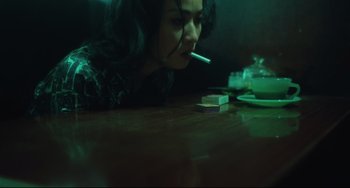 Movie still from “Days of Being Wild” (1990), directed by Kar-Wai Wong – A woman smoking a cigarette while sitting at a table; Close Up shot, High angle