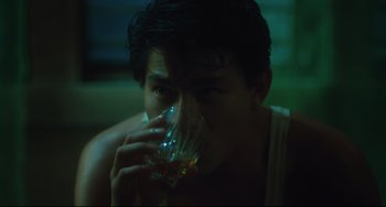 Movie still from “Days of Being Wild” (1990), directed by Kar-Wai Wong – A man drinking a glass of alcohol in a dark room; Close Up shot, High angle