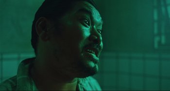 Movie still from “Days of Being Wild” (1990), directed by Kar-Wai Wong – A man's face in a green light; Close Up shot, Over the shoulder angle