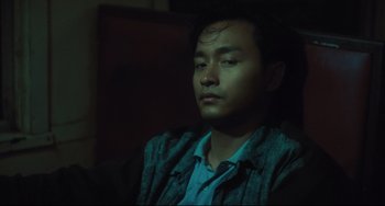 Movie still from “Days of Being Wild” (1990), directed by Kar-Wai Wong – A man sitting in a chair with his eyes wide open; Close Up shot, Low angle