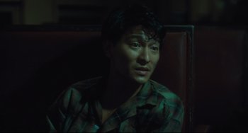 Movie still from “Days of Being Wild” (1990), directed by Kar-Wai Wong – A man sitting in a chair looking at the camera; Close Up shot, High angle