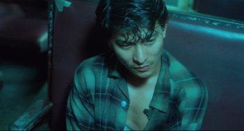Movie still from “Days of Being Wild” (1990), directed by Kar-Wai Wong – A man with wet hair sitting on a couch; Close Up shot, High angle
