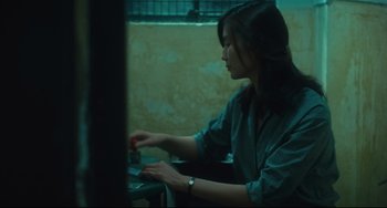 Movie still from “Days of Being Wild” (1990), directed by Kar-Wai Wong – A woman sitting in front of a computer keyboard; Medium shot, Over the shoulder angle