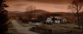 Movie still from “Days of Thunder” (1990), directed by Tony Scott – A car parked on the side of a road near a house; Extreme Wide shot, High angle