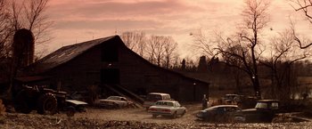 Movie still from “Days of Thunder” (1990), directed by Tony Scott – A group of cars parked next to each other in front of a barn; Extreme Wide shot, Low angle