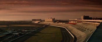 Movie still from “Days of Thunder” (1990), directed by Tony Scott – An image of an empty stadium at dusk time; Extreme Wide shot, High angle