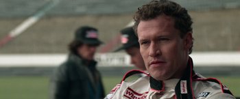 Movie still from “Days of Thunder” (1990), directed by Tony Scott – A person wearing a racing suit; Close Up shot, Low angle