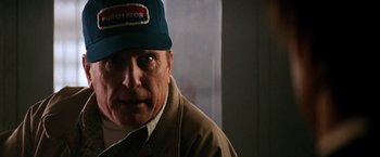 Movie still from “Days of Thunder” (1990), directed by Tony Scott – An older man wearing a blue hat and a brown jacket; Close Up shot, Low angle