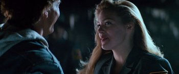 Movie still from “Days of Thunder” (1990), directed by Tony Scott – A woman with long blonde hair is talking to a man; Close Up shot, Over the shoulder angle