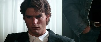 Movie still from “Days of Thunder” (1990), directed by Tony Scott – A person wearing a suit and tie; Close Up shot, Over the shoulder angle