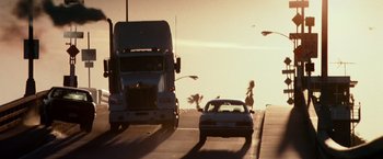 Movie still from “Days of Thunder” (1990), directed by Tony Scott – A truck and a car on a road; Extreme Wide shot, Low angle