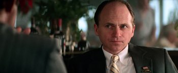 Movie still from “Days of Thunder” (1990), directed by Tony Scott – A person wearing a suit and tie; Close Up shot, Low angle