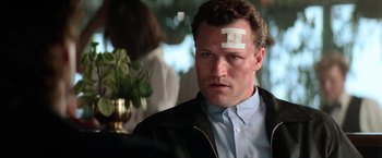 Movie still from “Days of Thunder” (1990), directed by Tony Scott – A man with a sticker on his forehead; Close Up shot, Low angle