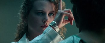 Movie still from “Days of Thunder” (1990), directed by Tony Scott – A woman looking at her watch in the mirror; Close Up shot, Over the shoulder angle