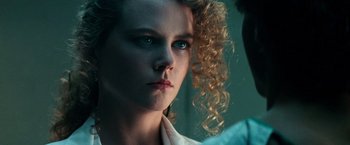 Movie still from “Days of Thunder” (1990), directed by Tony Scott – A person with curly red hair; Close Up shot, Over the shoulder angle