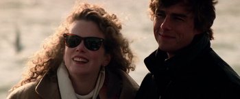 Movie still from “Days of Thunder” (1990), directed by Tony Scott – A man and a woman smiling for the camera; Close Up shot, Low angle