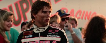 Movie still from “Days of Thunder” (1990), directed by Tony Scott – A race car driver wearing a racing suit; Close Up shot, Over the shoulder angle