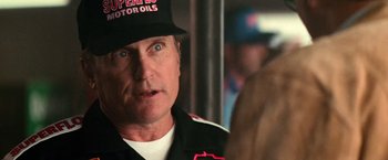 Movie still from “Days of Thunder” (1990), directed by Tony Scott – A person wearing a hat; Close Up shot, Over the shoulder angle