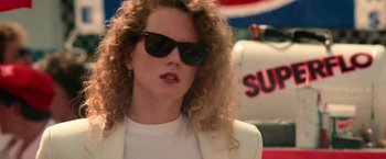 Movie still from “Days of Thunder” (1990), directed by Tony Scott – A person wearing sunglasses and a jacket; Close Up shot, Over the shoulder angle