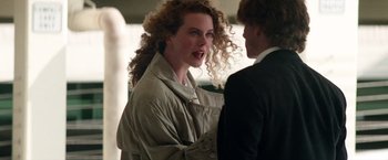 Movie still from “Days of Thunder” (1990), directed by Tony Scott – A woman with curly red hair talking to a man in a suit; Close Up shot, Over the shoulder angle