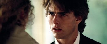 Movie still from “Days of Thunder” (1990), directed by Tony Scott – A person wearing a suit and tie; Close Up shot, Over the shoulder angle