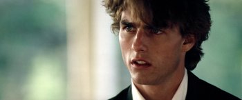 Movie still from “Days of Thunder” (1990), directed by Tony Scott – A person wearing a suit and tie; Close Up shot, Over the shoulder angle