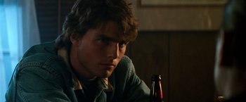 Movie still from “Days of Thunder” (1990), directed by Tony Scott – A man sitting in front of a bottle of beer; Close Up shot, Over the shoulder angle