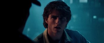 Movie still from “Days of Thunder” (1990), directed by Tony Scott – A young man is looking into the camera; Close Up shot, Over the shoulder angle