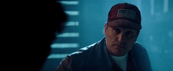 Movie still from “Days of Thunder” (1990), directed by Tony Scott – A person wearing a hat; Close Up shot, Over the shoulder angle