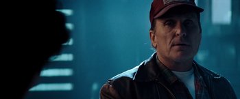 Movie still from “Days of Thunder” (1990), directed by Tony Scott – An older man wearing a hat and a leather jacket; Close Up shot, Low angle