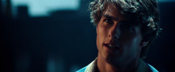 Movie still from “Days of Thunder” (1990), directed by Tony Scott – Close up of a young man's face in a dark room; Close Up shot, Over the shoulder angle