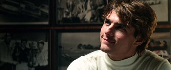 Movie still from “Days of Thunder” (1990), directed by Tony Scott – A man in a white shirt is looking up; Close Up shot, Over the shoulder angle