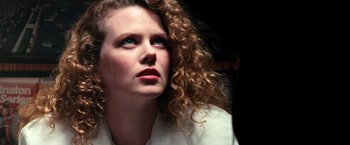 Movie still from “Days of Thunder” (1990), directed by Tony Scott – A person with curly hair looking up; Close Up shot, Overhead angle