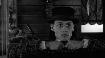 Movie still from “Dead Man” (1995), directed by Jim Jarmusch – A man in a top hat and tie; Close Up shot, Low angle