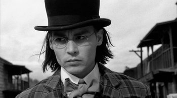Movie still from “Dead Man” (1995), directed by Jim Jarmusch – A man wearing a top hat and a tie; Close Up shot, Over the shoulder angle
