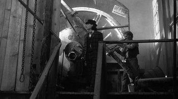 Movie still from “Dead Man” (1995), directed by Jim Jarmusch – A man in a suit and hat standing next to a man in a suit and hat; Wide shot, Low angle