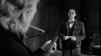 Movie still from “Dead Man” (1995), directed by Jim Jarmusch – A man in a suit and tie looking at himself in the mirror; Medium shot, Over the shoulder angle