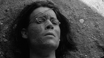 Movie still from “Dead Man” (1995), directed by Jim Jarmusch – A person with glasses is laying on the ground; Close Up shot, Overhead angle