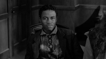 Movie still from “Dead Man” (1995), directed by Jim Jarmusch – A black and white photo of a man wearing a suit and tie; Close Up shot, Low angle