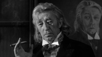 An old man with long hair and a suit and tie