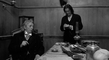 Movie still from “Dead Man” (1995), directed by Jim Jarmusch – Two men sitting at a dinner table in a restaurant; Medium shot, Over the shoulder angle