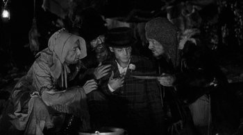 Movie still from “Dead Man” (1995), directed by Jim Jarmusch – A group of people gathered around a man in a hat; Medium shot, High angle