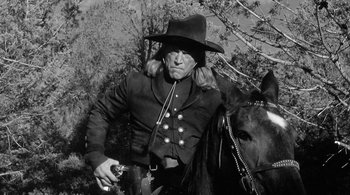 Movie still from “Dead Man” (1995), directed by Jim Jarmusch – A man in a cowboy hat is riding a horse; Medium shot, Low angle