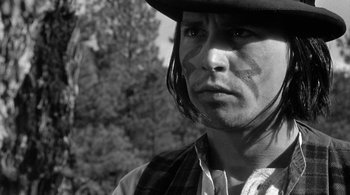 Movie still from “Dead Man” (1995), directed by Jim Jarmusch – A person wearing a hat and looking at the camera; Close Up shot, Low angle
